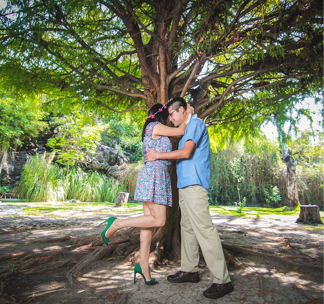 Pareja abrazada bajo un árbol durante su sesión fotográfica