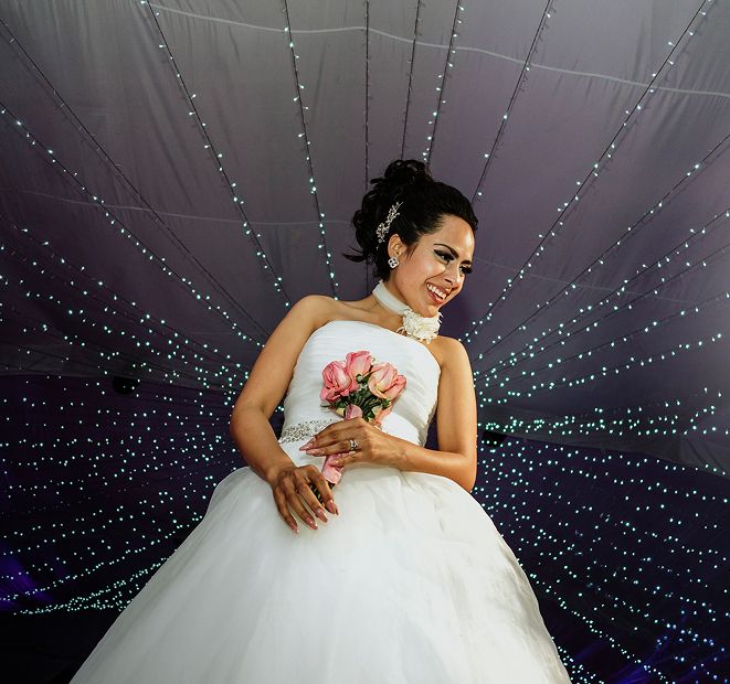 Novia bajo bóveda de luces en la recepción