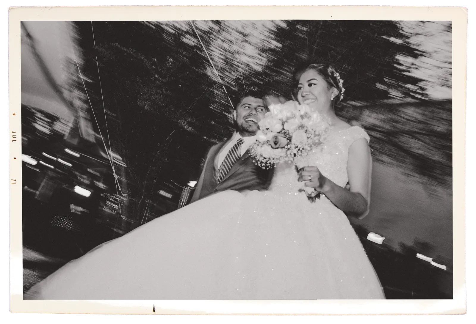 Los novios saliendo de noche, retrato en blanco y negro con efecto de movimiento